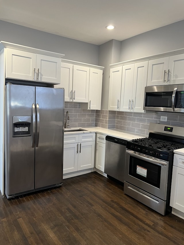 kitchen featuring stainless steel appliances, light countertops, white cabinetry, backsplash, and recessed lighting