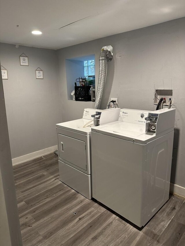 laundry room with washing machine and clothes dryer, dark wood-type flooring, and recessed lighting
