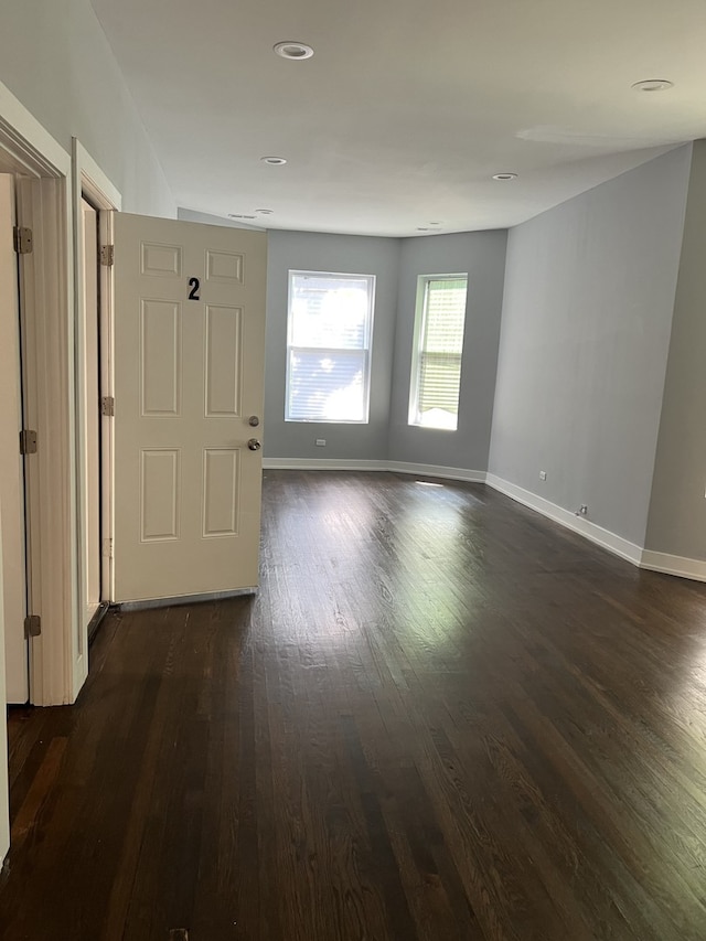 spare room with dark wood-style flooring and recessed lighting