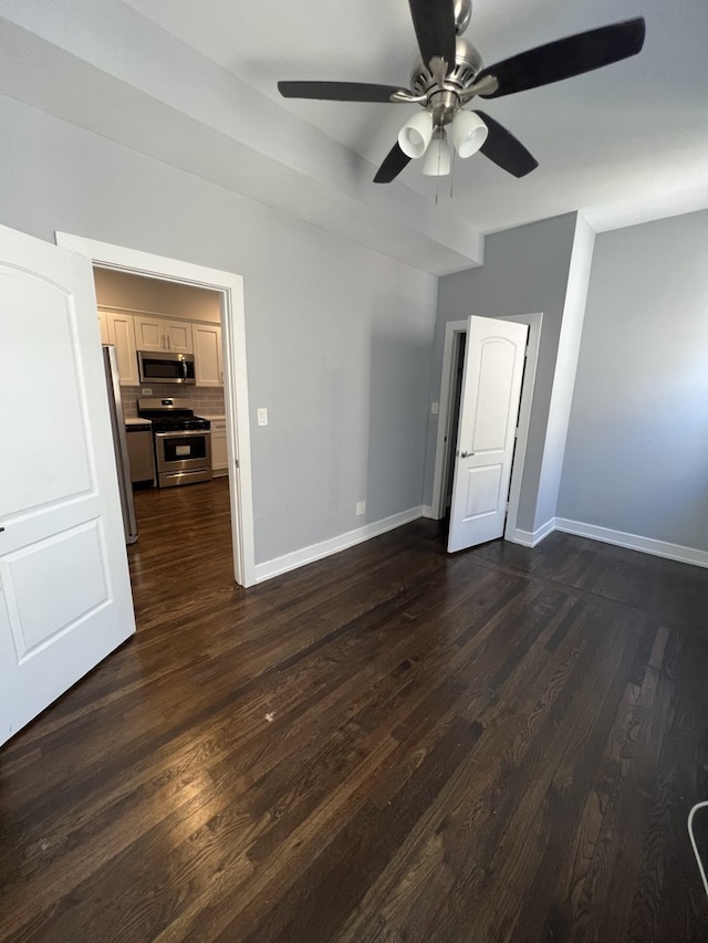 empty room featuring a ceiling fan and dark wood-style flooring