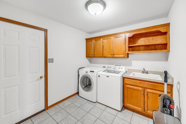 laundry area featuring cabinets, separate washer and dryer, sink, and light tile patterned floors