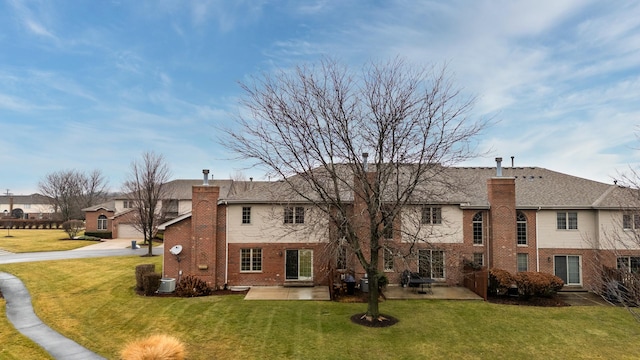 rear view of house with a lawn and a patio