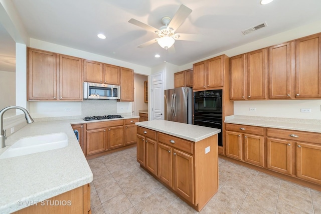 kitchen featuring a center island, sink, decorative backsplash, ceiling fan, and stainless steel appliances