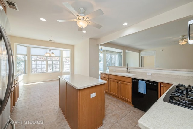 kitchen featuring a wealth of natural light, sink, black appliances, pendant lighting, and a center island