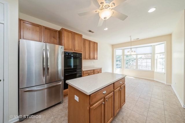 kitchen featuring stainless steel refrigerator, hanging light fixtures, black double oven, light tile patterned floors, and ceiling fan with notable chandelier