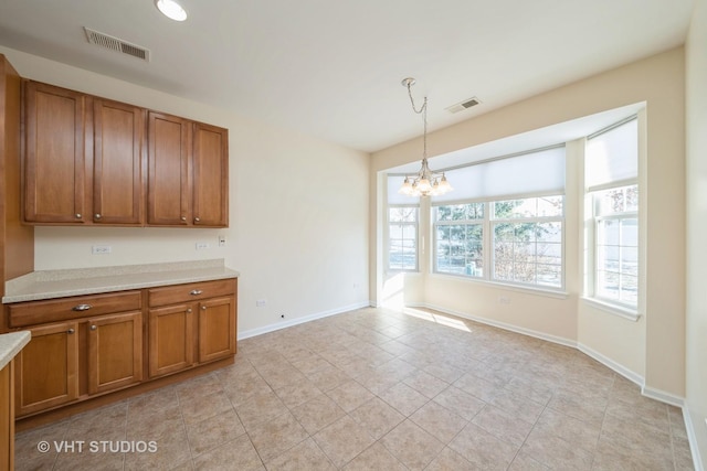 kitchen featuring a chandelier, light tile patterned floors, and hanging light fixtures