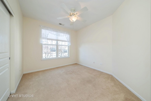 spare room with light carpet and ceiling fan