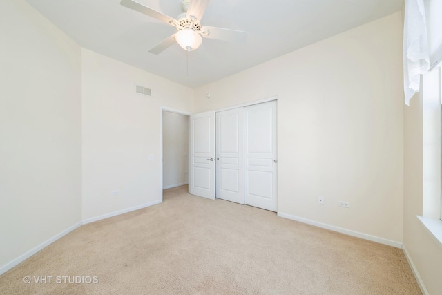 unfurnished bedroom featuring light carpet, a closet, and ceiling fan