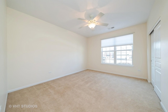 unfurnished bedroom featuring ceiling fan, a closet, and light carpet