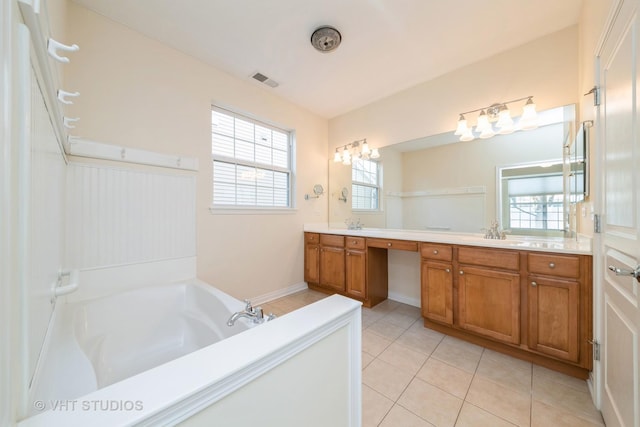 bathroom with tile patterned flooring, vanity, and a tub