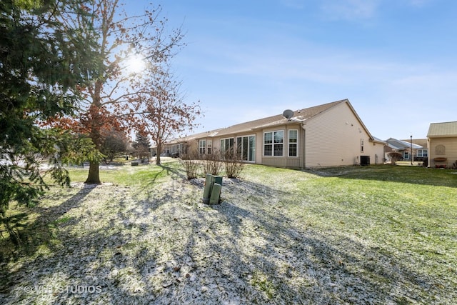 back of property with a lawn and central air condition unit