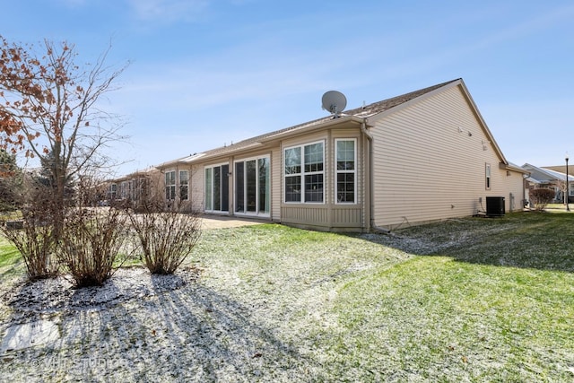 back of property featuring central air condition unit and a lawn