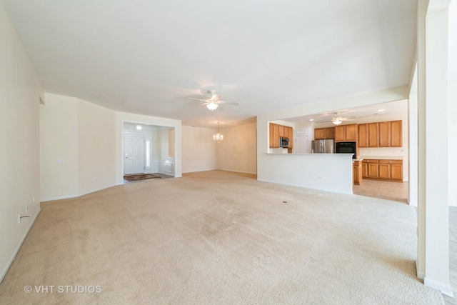 unfurnished living room featuring ceiling fan with notable chandelier and light colored carpet