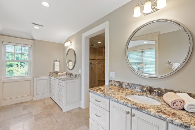 bathroom with a shower with door and vanity