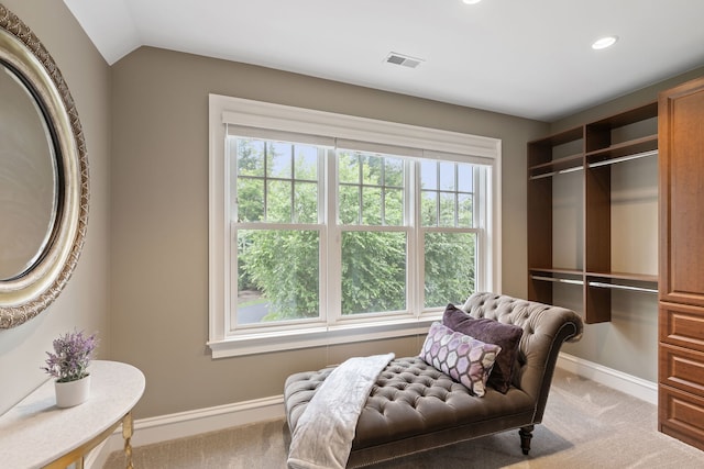 sitting room with vaulted ceiling, light colored carpet, and plenty of natural light