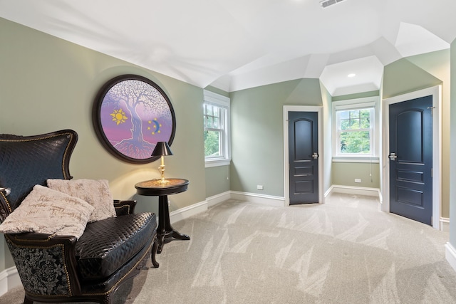 sitting room featuring light carpet and vaulted ceiling