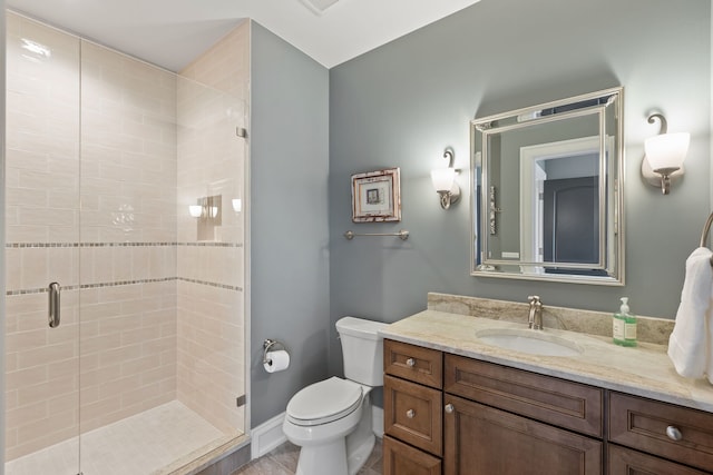 bathroom featuring a shower with door, toilet, and vanity