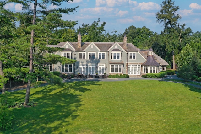 rear view of property featuring a lawn