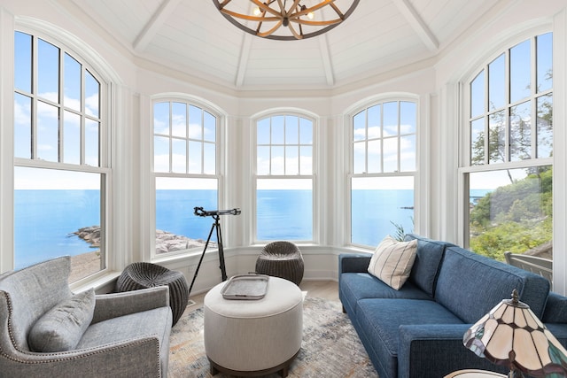 sunroom with wooden ceiling, a water view, and lofted ceiling with beams