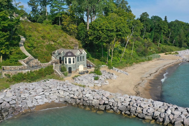 birds eye view of property featuring a beach view and a water view