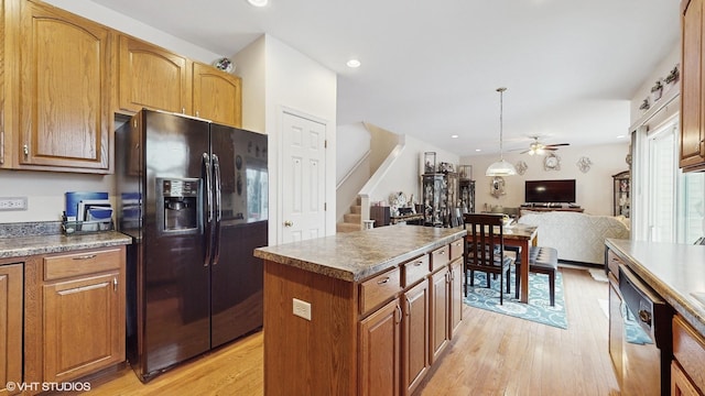 kitchen featuring dishwasher, a center island, black refrigerator with ice dispenser, ceiling fan, and light wood-type flooring