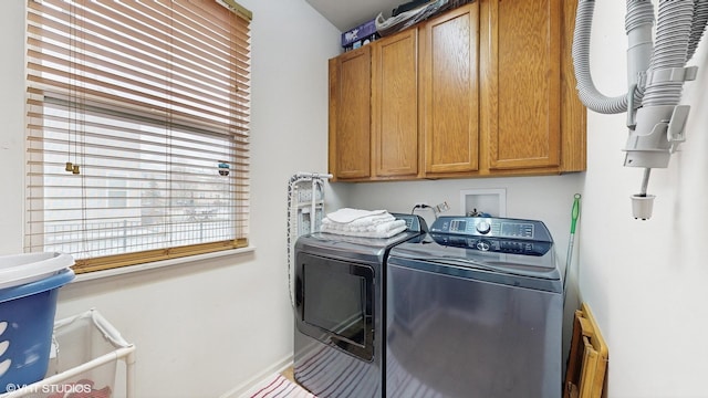 clothes washing area featuring cabinets and independent washer and dryer