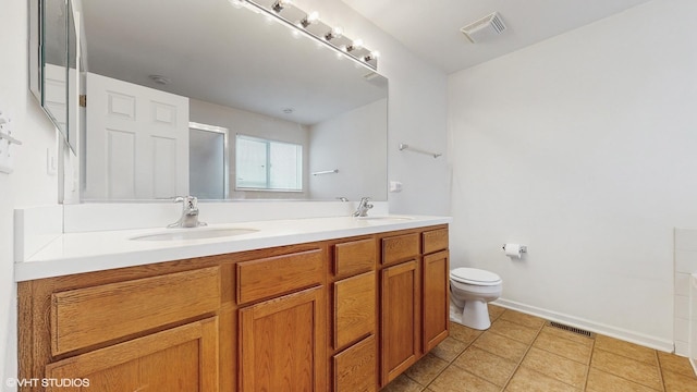 bathroom featuring tile patterned floors, vanity, toilet, and a shower with door