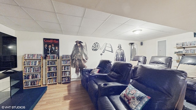 cinema room featuring hardwood / wood-style floors and a paneled ceiling