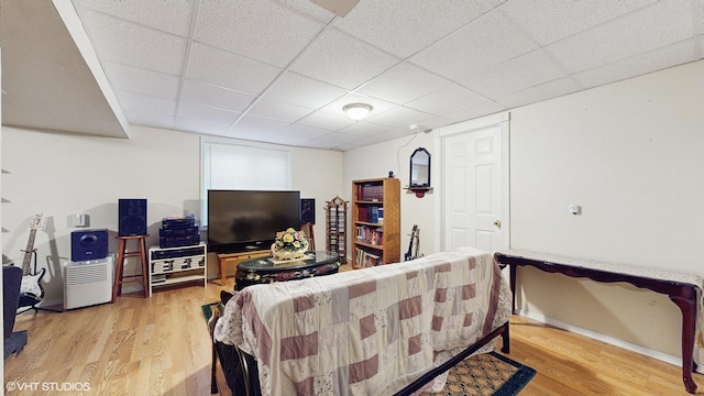 living room featuring hardwood / wood-style flooring and a drop ceiling