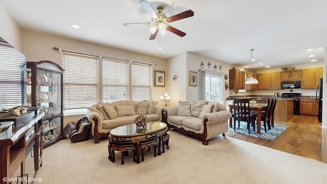 living room featuring light hardwood / wood-style flooring and ceiling fan