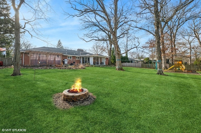 view of yard featuring a playground and an outdoor fire pit