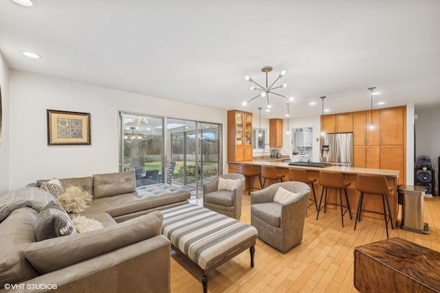 living room featuring a notable chandelier and light wood-type flooring