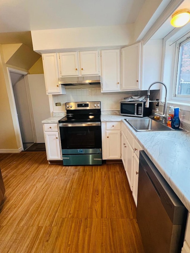 kitchen featuring white cabinets, appliances with stainless steel finishes, tasteful backsplash, and sink