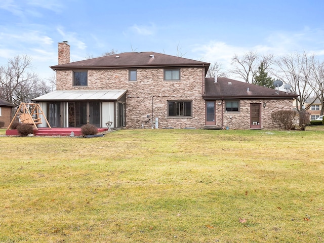 back of property with a sunroom and a yard