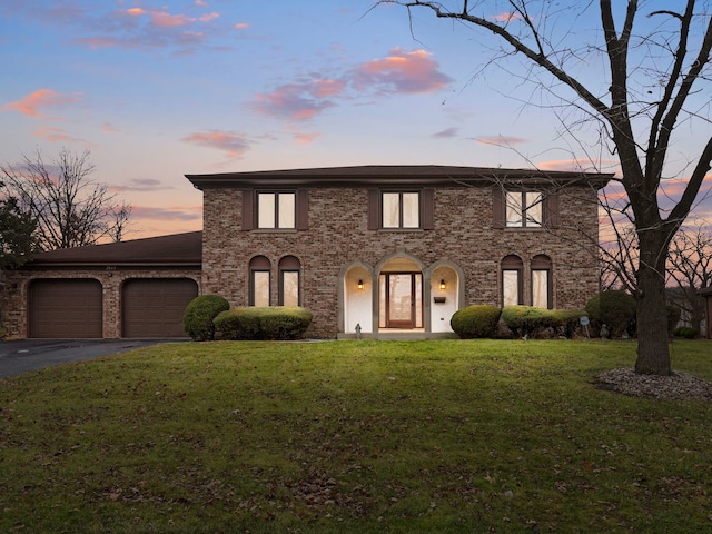 view of front of property with a garage and a yard