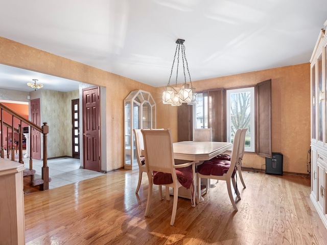 dining space with a chandelier and light wood-type flooring