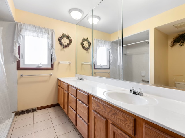 bathroom featuring toilet, vanity, tile patterned floors, and plenty of natural light