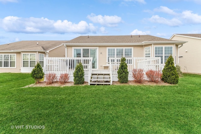 rear view of house featuring a lawn and a deck