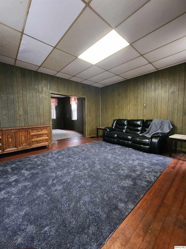 living room featuring a paneled ceiling and dark hardwood / wood-style floors