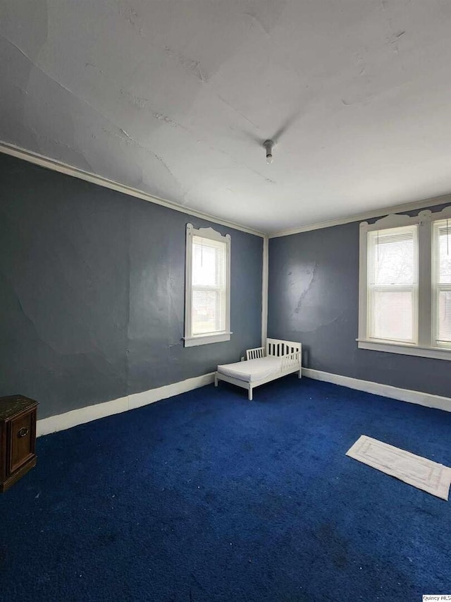 unfurnished bedroom with ornamental molding and dark colored carpet