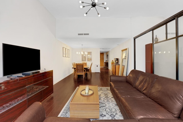 living room with an inviting chandelier and dark wood-type flooring