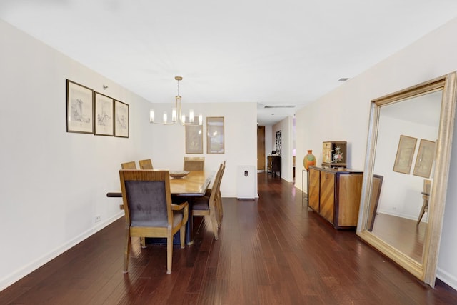 dining area featuring dark hardwood / wood-style flooring and an inviting chandelier