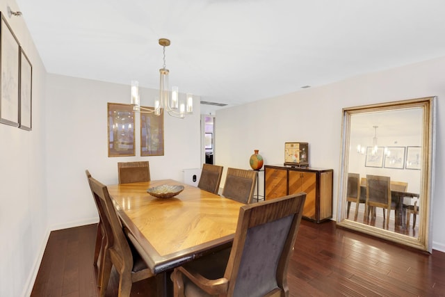 dining room with dark wood-type flooring and a notable chandelier