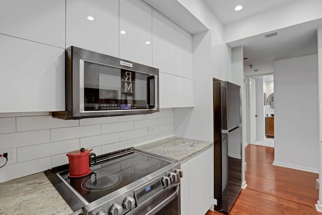 kitchen with white cabinetry, electric range, tasteful backsplash, light hardwood / wood-style flooring, and refrigerator