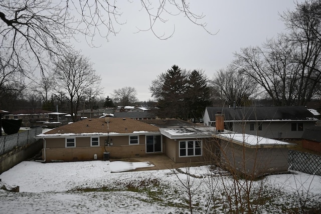 view of snow covered rear of property