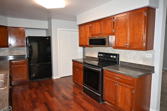 kitchen featuring tasteful backsplash, dark wood-type flooring, and black appliances