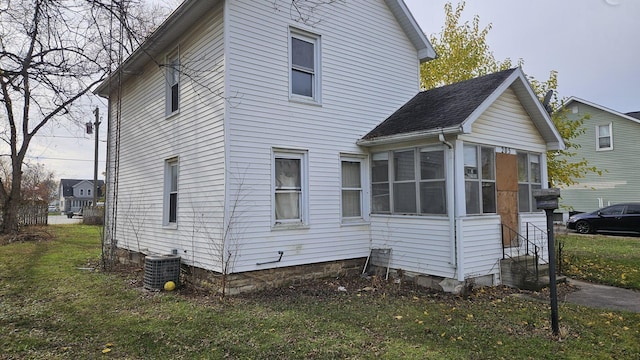 view of home's exterior featuring a yard, central AC unit, and a sunroom