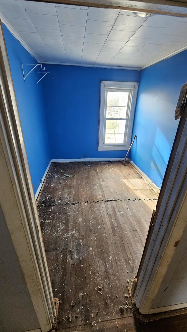 empty room featuring hardwood / wood-style flooring and ornamental molding