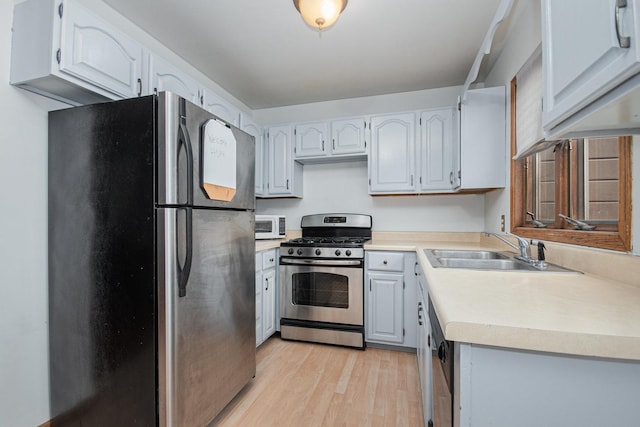 kitchen with white cabinets, appliances with stainless steel finishes, and sink