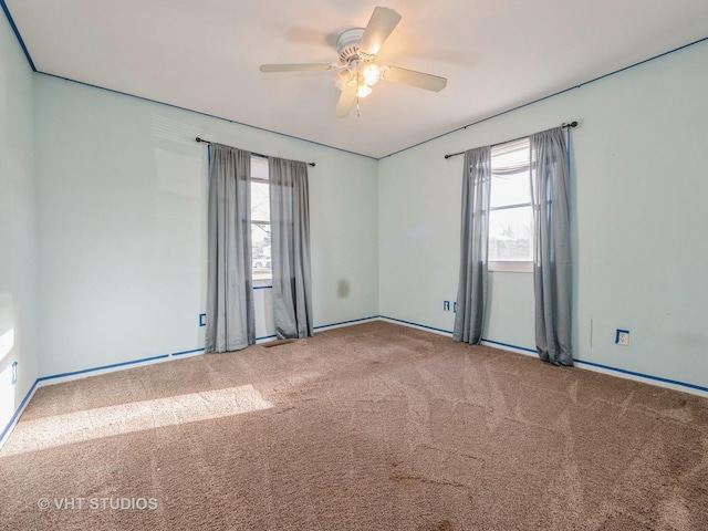 carpeted spare room with ceiling fan